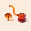 Two glass smoking devices, one orange and one red, on a beige background.