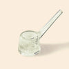 Clear ribbed glass water pipe by NWTN Home with a long angled stem, photographed on a plain warm beige background.