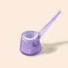 A NWTN Home translucent lavender purple glass pipe with a flared ribbed bowl and a long angled mouthpiece, shown on a solid light beige background.