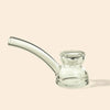 Clear glass water pipe by NWTN Home with a curved mouthpiece and a small flared base, photographed on a plain warm beige background.