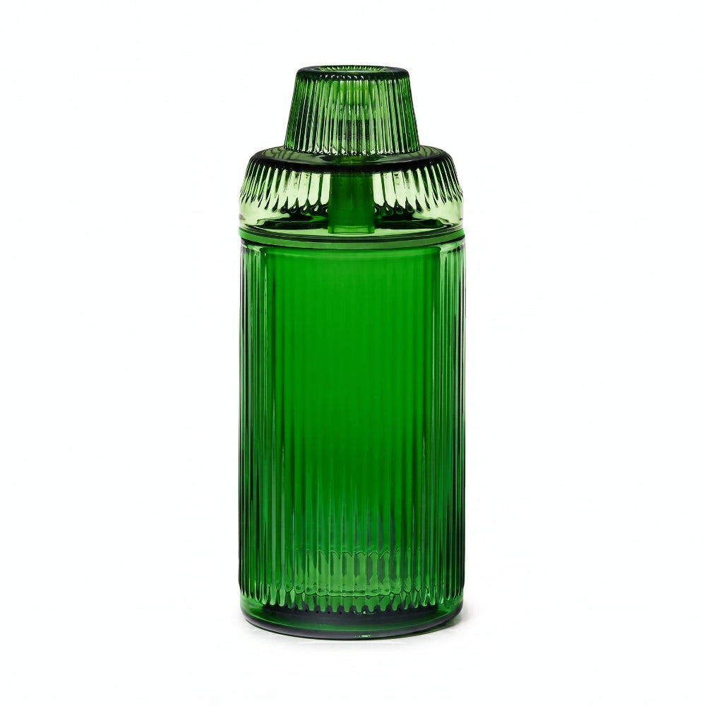 Green glass container with ribbed design on a white background